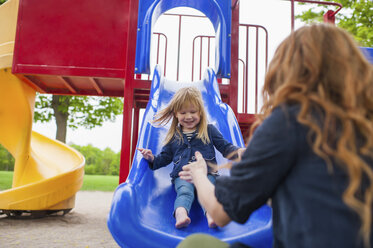 Mother catching daughter at the bottom of slide - ISF19020