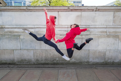 Young male and female dancer mid air in city - ISF19034