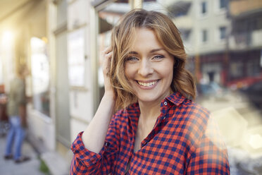 Portrait of smiling woman in the city - PNEF00785