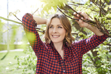 Portrait of smiling woman in a park - PNEF00789