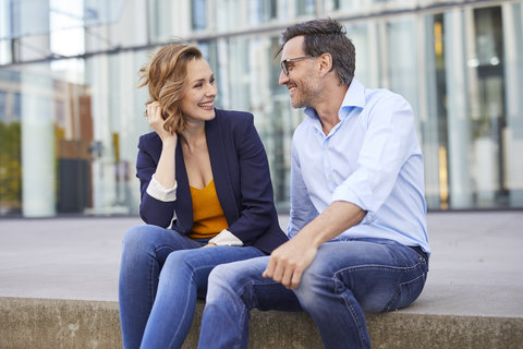 Two business people sitting outdoors talking stock photo