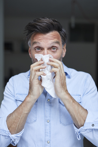Portrait of man blowing nose stock photo
