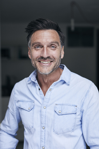 Portrait of laughing man wearing light blue denim shirt stock photo