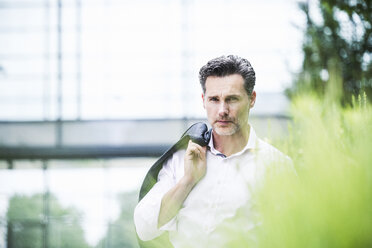 Portrait of serious businessman outside office building - UUF14659