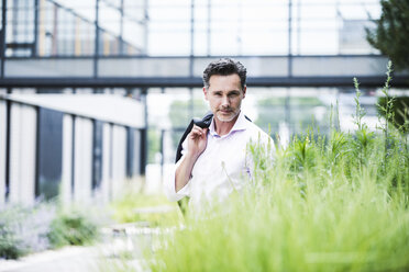 Portrait of confident businessman outside office building - UUF14660