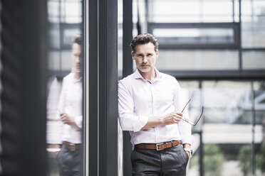 Portrait of confident businessman outside office building - UUF14672