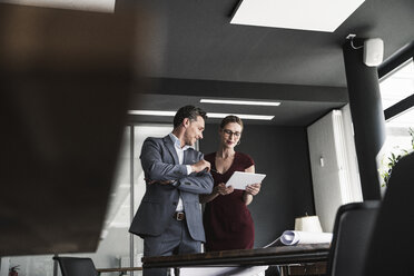 Businesswoman and businessman sharing tablet in office - UUF14777