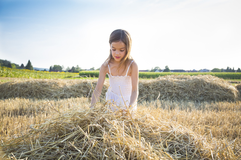 Kleines Mädchen steht in einem verwilderten Feld, lizenzfreies Stockfoto