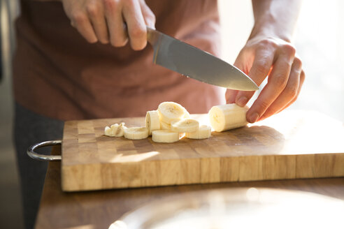 Man's hand chopping banana with kitchen knife - MFRF01152