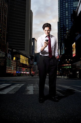 Businessman in city with smartphone stock photo