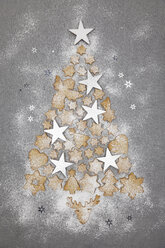 Christmas cookies and white stars forming Christmas Ttee on grey background - GWF05618