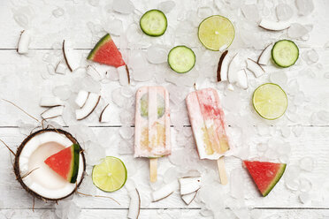 Hausgemachte Wassermelonen-Kokos-Eislutscher mit Limetten- und Gurkenscheiben, frischer Kokosnuss und Wassermelonenstücken auf Eiswürfeln - GWF05625