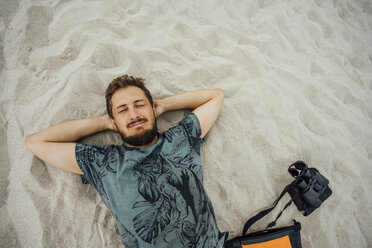 Mann mit Fernglas ruht sich am Strand aus - VPIF00409