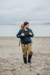 Man with backpack, walking on the beach - VPIF00413