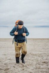 Man with backpack, walking on the beach - VPIF00414