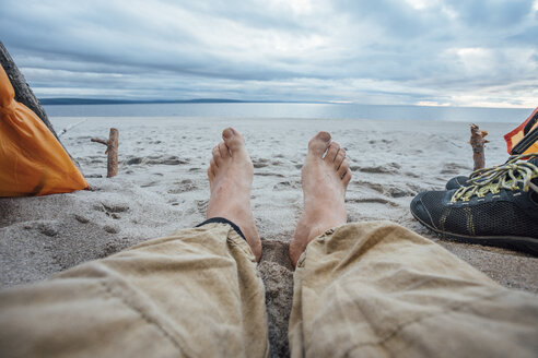 Füße eines Mannes, der am Strand liegt - VPIF00419