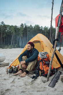 Rucksacktourist sitzt vor seinem Zelt am Strand - VPIF00420