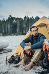 Rucksacktourist sitzt vor seinem Zelt am Strand - VPIF00422