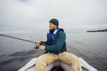 Man sitting on boat fishing with fishing rod - VPIF00427