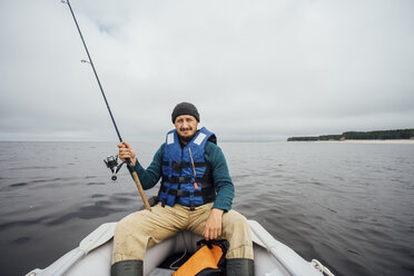 Mann sitzt auf einem Boot und fischt mit einer Angelrute - VPIF00430
