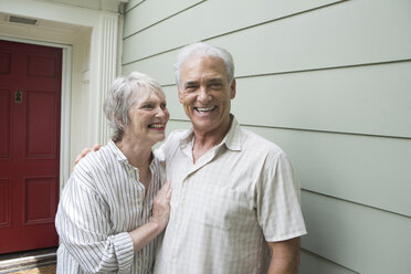 Senior couple smiling together outside house, portrait - ISF19147