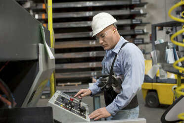 Worker at control panel in metal plant - ISF19202