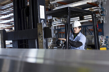 Worker driving forklift in metal plant - ISF19211