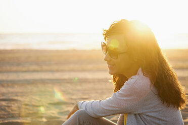 Smiling woman in sunglasses on beach - ISF19224