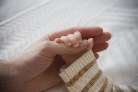 Kleiner Junge hält die Hand der Mutter, Nahaufnahme, lizenzfreies Stockfoto