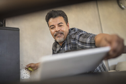 Handwerker schaut auf Tablet - ZEF15888