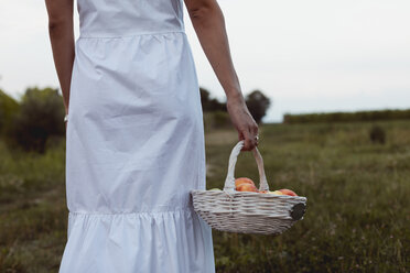 Frau geht mit Picknickkorb zum Weinberg - MAUF01591