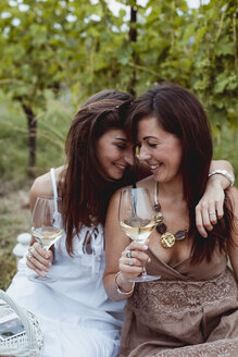 Freunde beim Sommerpicknick in einem Weinberg, Wein trinken - MAUF01637