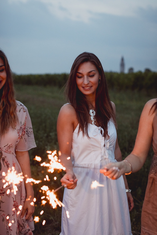 Friends having a picnic in a vinyard, burning sparklers stock photo