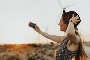Junge Frau nimmt Selfie bei Sonnenuntergang - OCAF00335