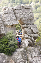 Mountain biking couple kissing on rock formation - ISF19584