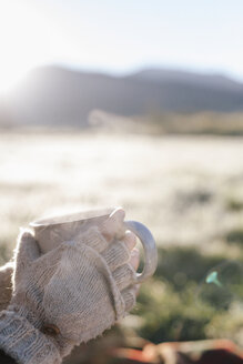 Eine Person mit Handschuhen hält ein heißes Getränk in den Händen. - MINF03201