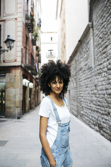 Spain, Barcelona, portrait of smiling woman with curly hair - JRFF01728