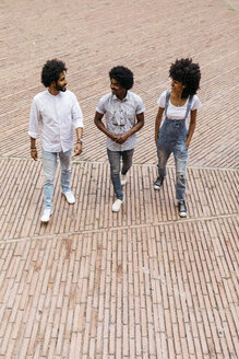 Three friends walking on a square having fun together - JRFF01738