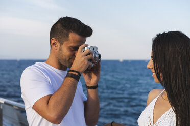 Junges urbanes Paar beim Fotografieren am Meer - AFVF01169