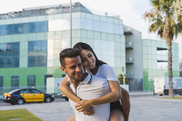 Happy couple in the city, man carrying his girlfriend piggyback - AFVF01189