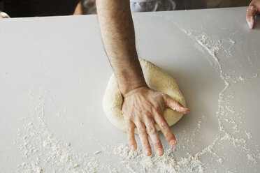 Nahaufnahme eines Bäckers, der Brotteig knetet und zu einer Kugel formt. - MINF03341