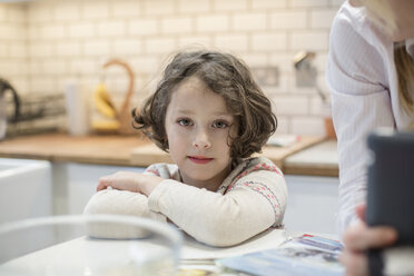 Ein Kind, ein junges Mädchen, das an einem Tisch sitzt und Weihnachtskarten bastelt. - MINF03422
