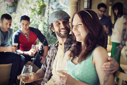 Eine Gruppe von Freunden, Männern und Frauen, die auf einer Hausparty Wein trinken. - MINF03447