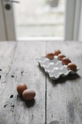 Fresh hen's eggs in a box and on a wooden table. - MINF03516