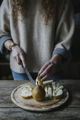 Eine Frau schneidet frisches Obst, Birnen. - MINF03520