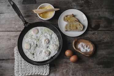 A dish of eggs, bread and sauce laid out on a table. - MINF03526