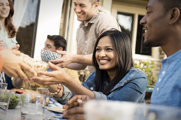 Friends around a table, men and women laughing and talking. - MINF03558