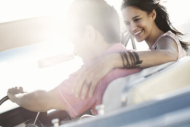 A young couple, man and woman in a pale blue convertible on the open road - MINF03580