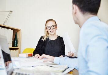 Zwei Personen sitzen bei einem Treffen an einem Tisch. - MINF03793