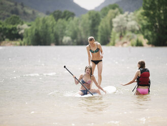 Teenager-Mädchen beim Stand Up Paddle Surfing auf einem See. - MINF03809